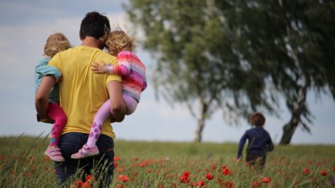 Family playing outside in field - Totally Life