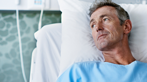 Man laying in hospital bed - Totally Life